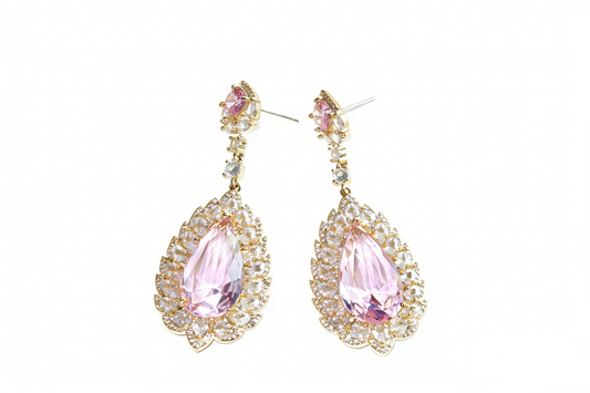 Close-up of pink teardrop halo earrings with vibrant pink center stone and clear crystal surround, sculptural modern heirloom jewelry for UK 2026 fashion trends.